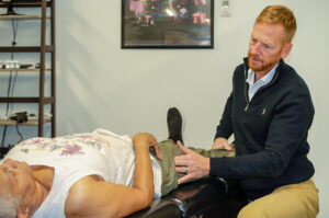 A chiropractor performing a spinal adjustment in a modern Denver clinic setting